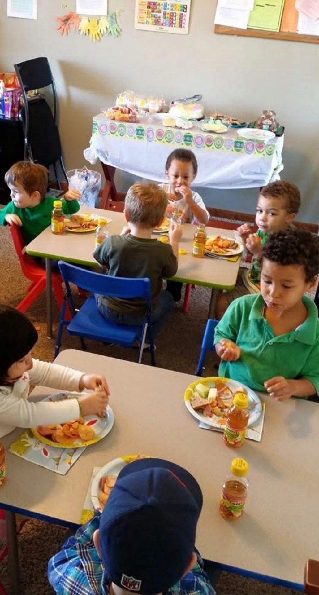 Children eating a healthy snack at classroom tables