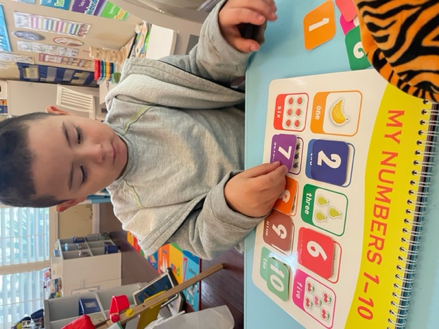 Child matching number cards on a My Numbers 1-10 board