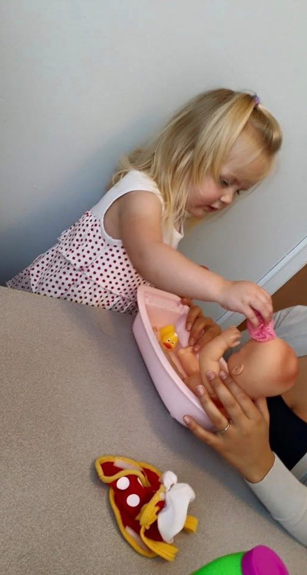 Child giving a baby doll a pretend bath