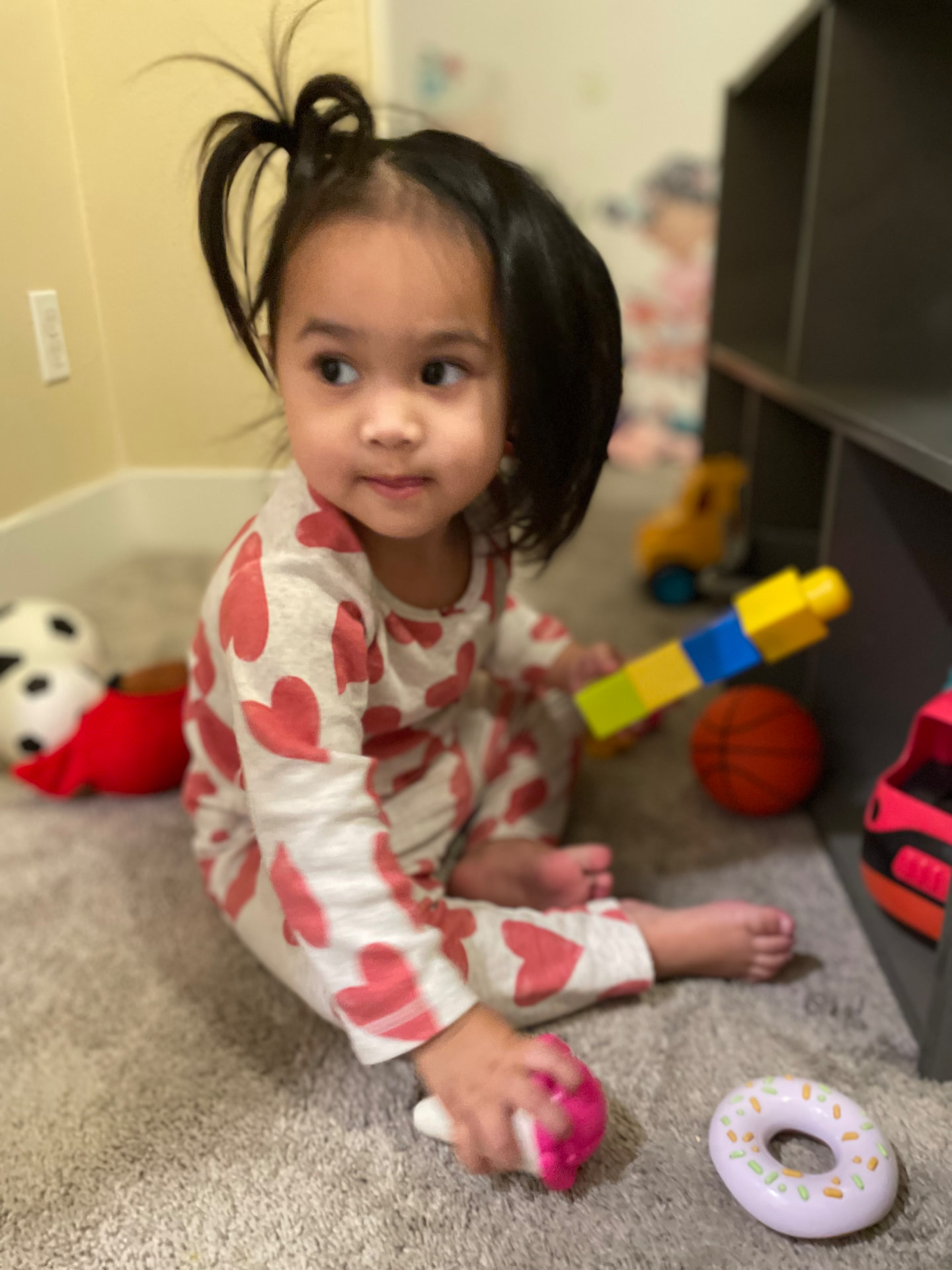 Toddler stacking colorful blocks on the play rug