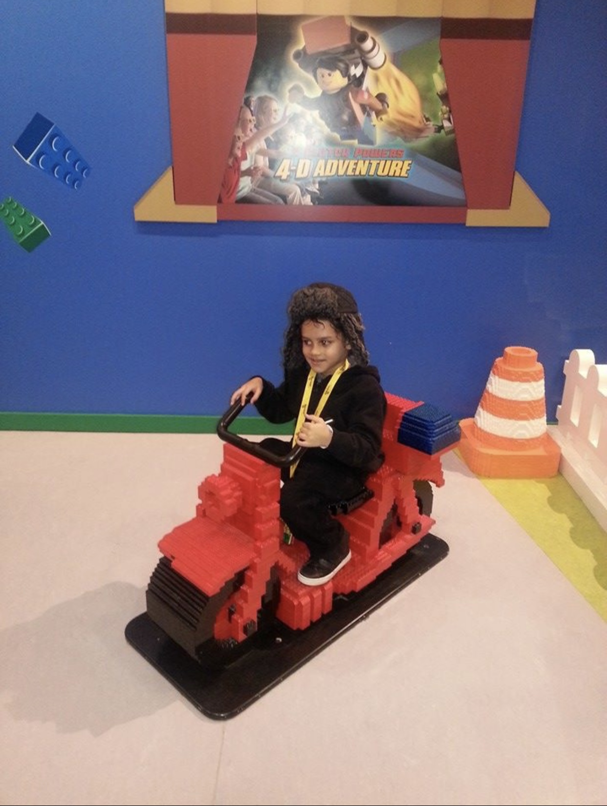 Child sitting on a large brick-built motorcycle on a field trip