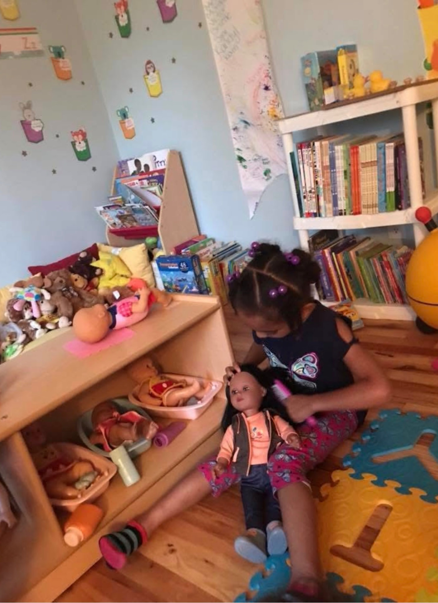 Child brushing a doll's hair in the cozy book and doll corner