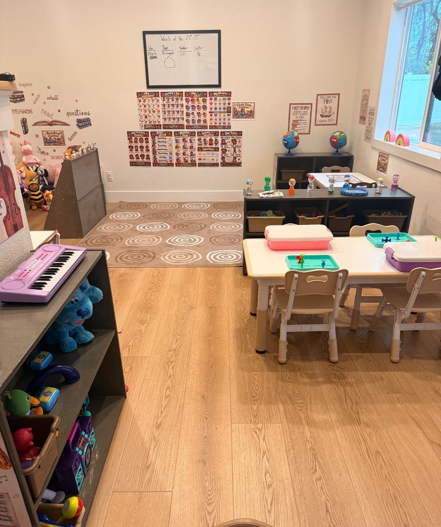 PreSchool Prep classroom with shelves of toys, a child-size activity table, and a wall of learning posters